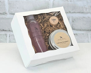 Body care gift set with handmade bubble bath and a soy candle in the scent Cabernet in a white box on a light background