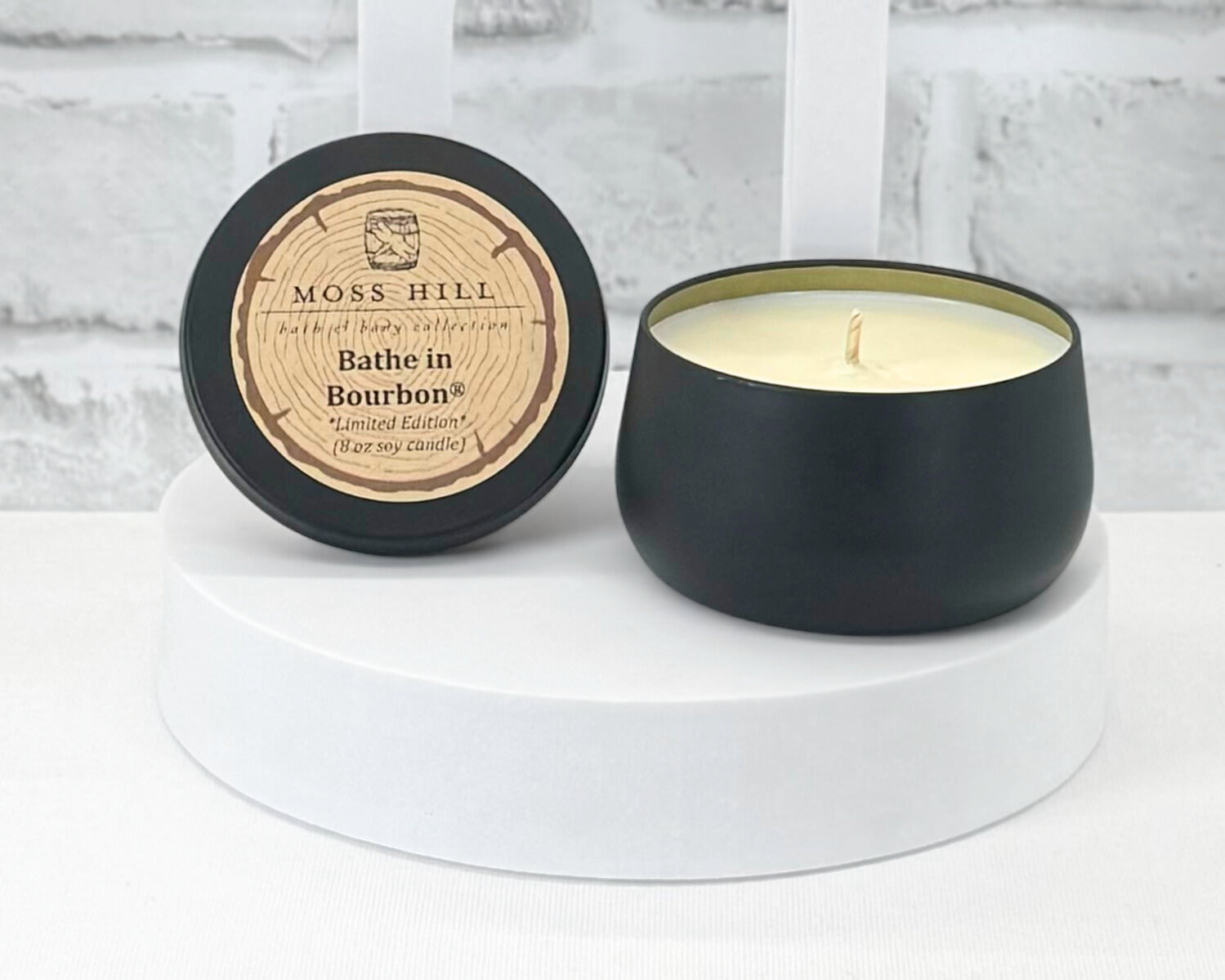 Locally made 8 oz soy candles. In a black container with a Moss Hill Bath & Body Collection sticker on the lid.