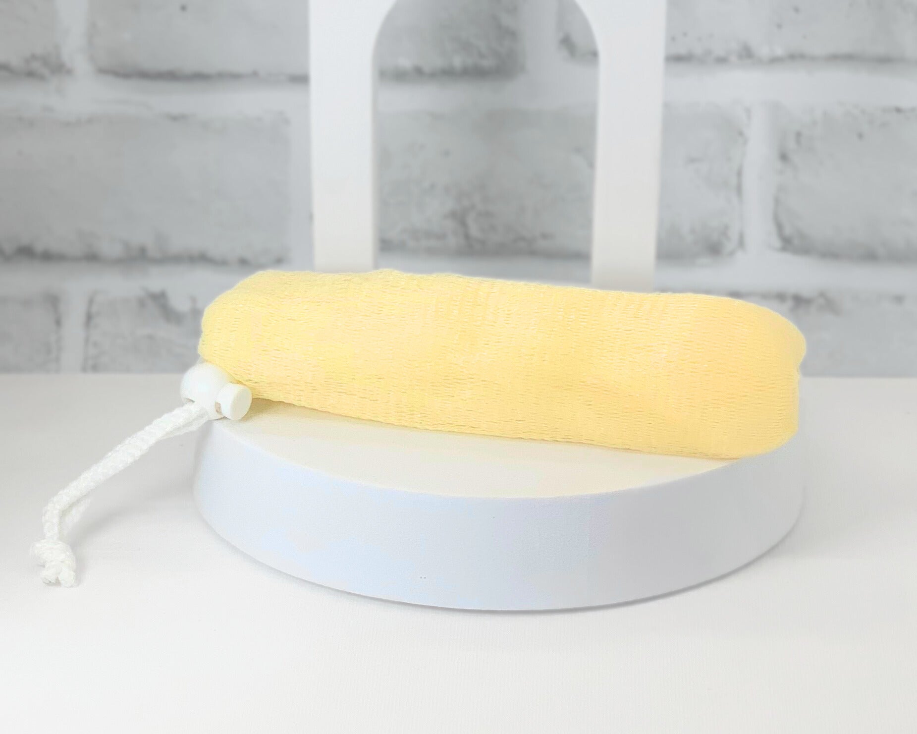 Reusable mesh loofah bag holding bar soap in shower