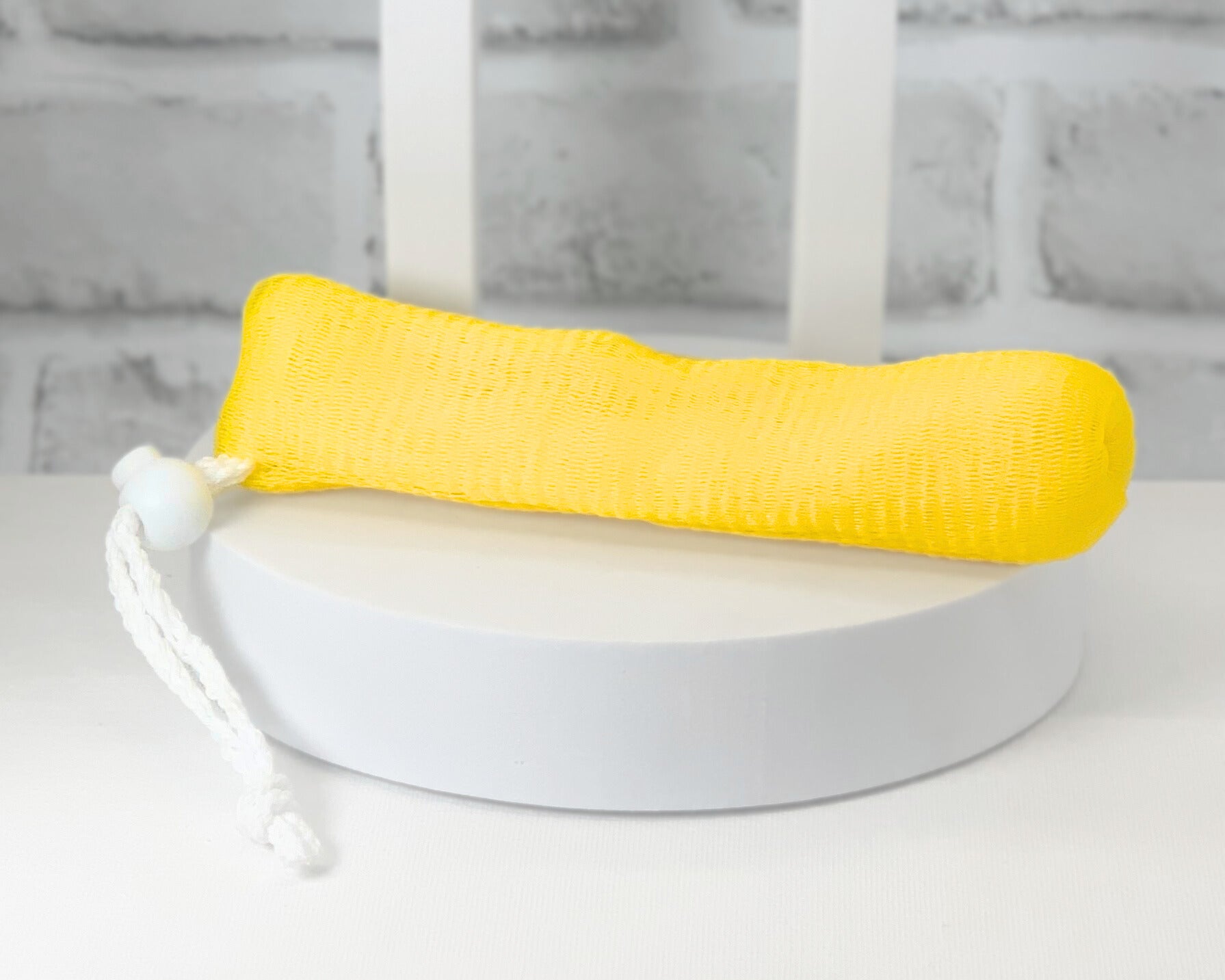 Bar soap inside exfoliating loofah pouch hanging in shower