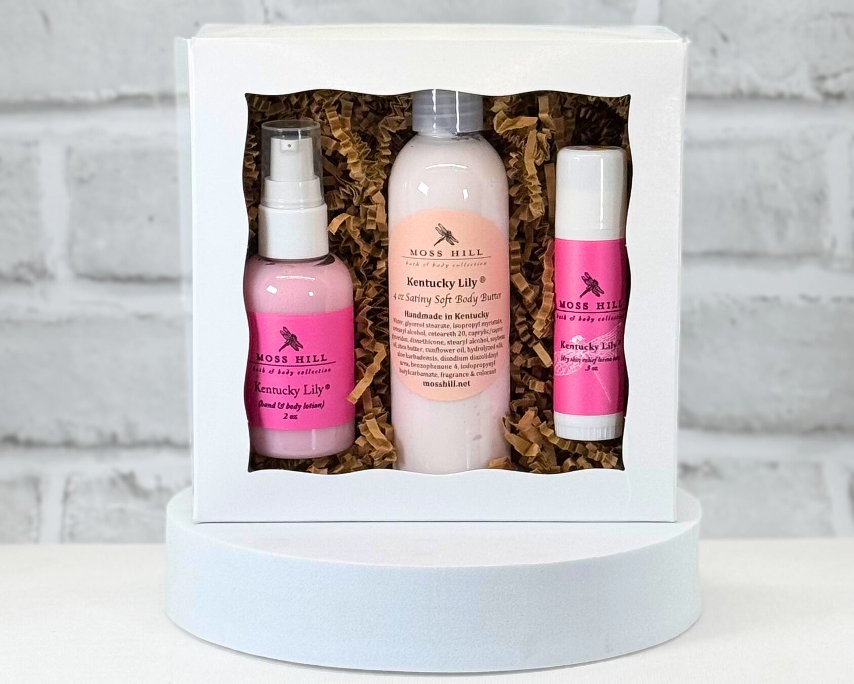 Three piece body gift set with 2 oz lotion, 4 ox body butter, and a moisturizing stick. All in the scent Kentucky Lily wrapped in a white box with brown filler paper.