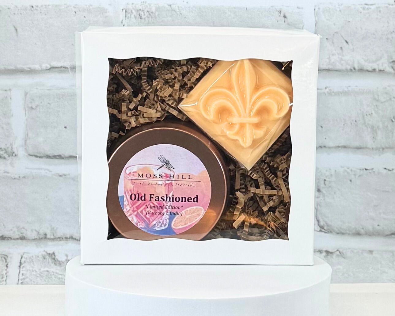 Two piece gift box set in the scent Old Fashioned. It comes with a handmade soap with a fleur-de-lis on top and an 8 oz soy candle.