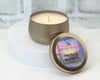 8 oz Soy Candle in the scent southern warmth. Hand-poured into a gold tin. Sitting on top of a white table.