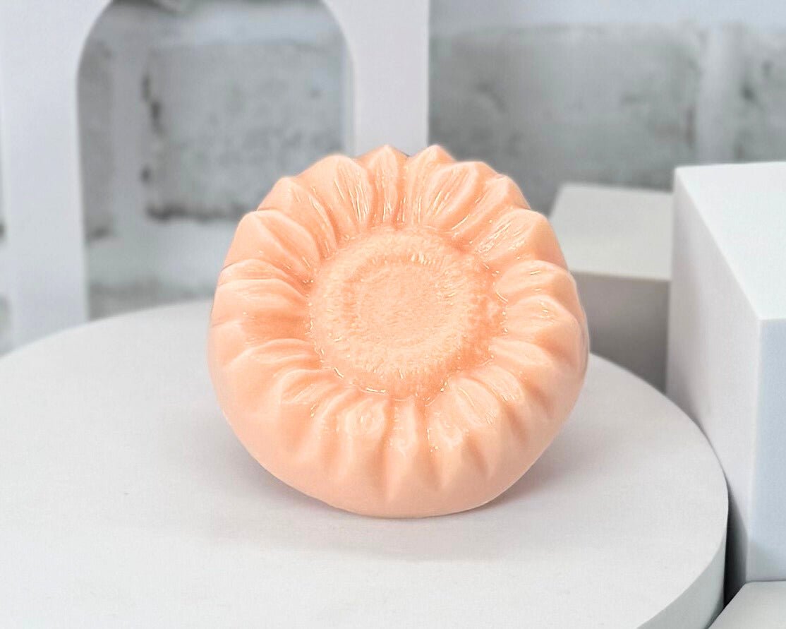 Pink handmade soap bar on a white surface with a blurred background