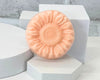 handmade soap in a sunflower shape. Sitting on a white table with a white backfground