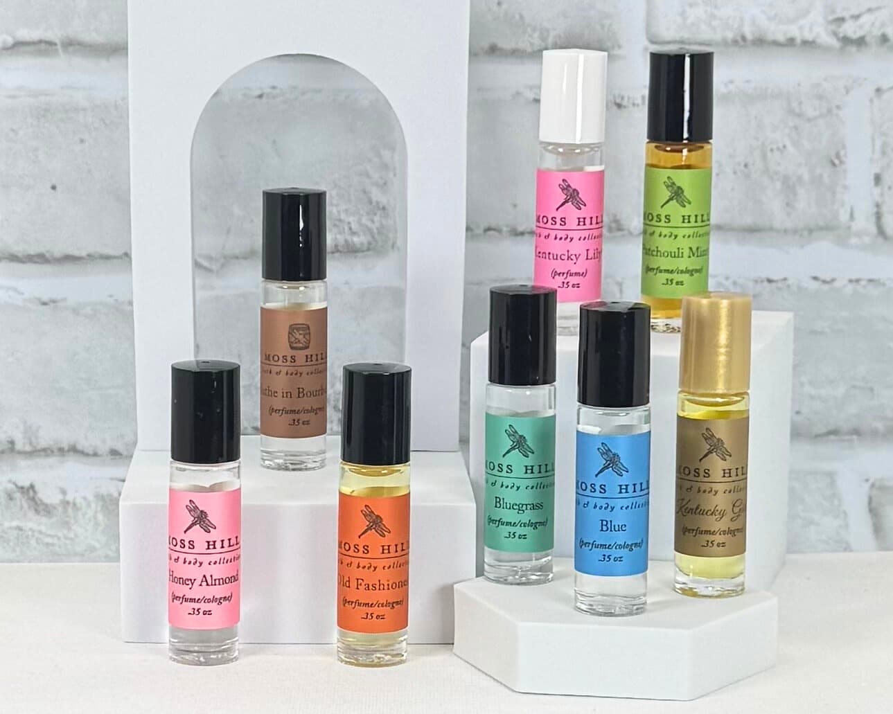 A collection of Moss Hill Roll-On Perfumes in signature scents on a white table with a white background.