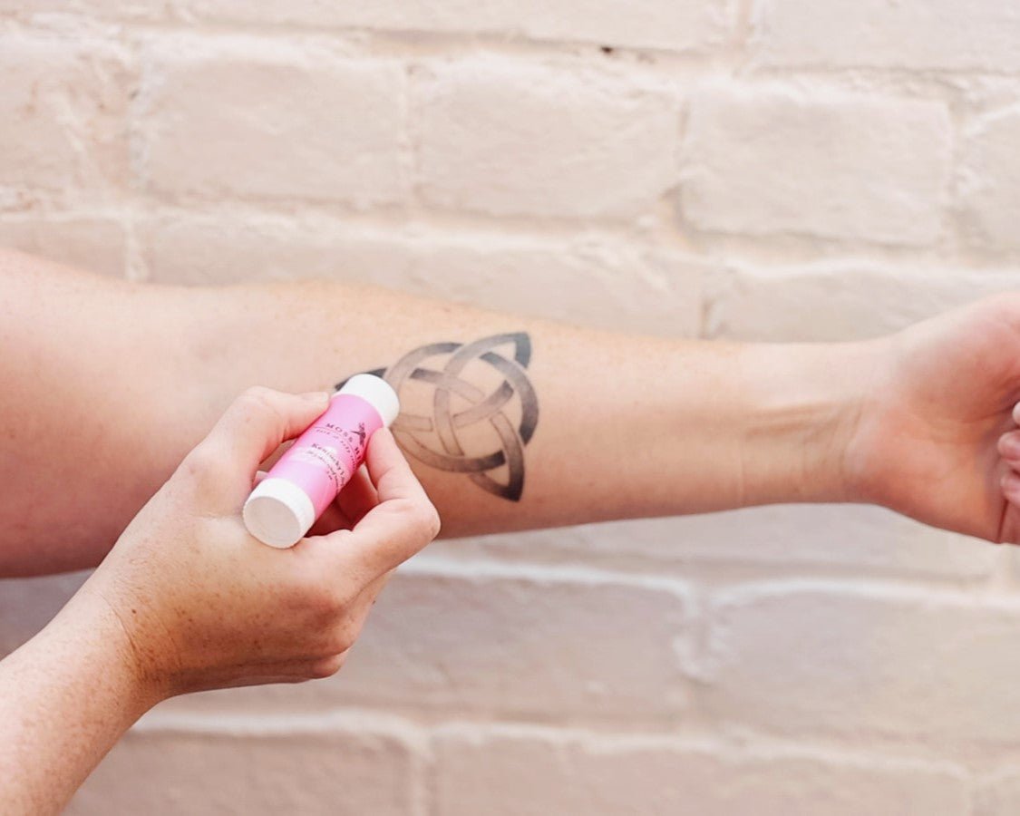 Tattoo body care with the dry skin relief lotion bar being used to hydrate an arm tattoo.