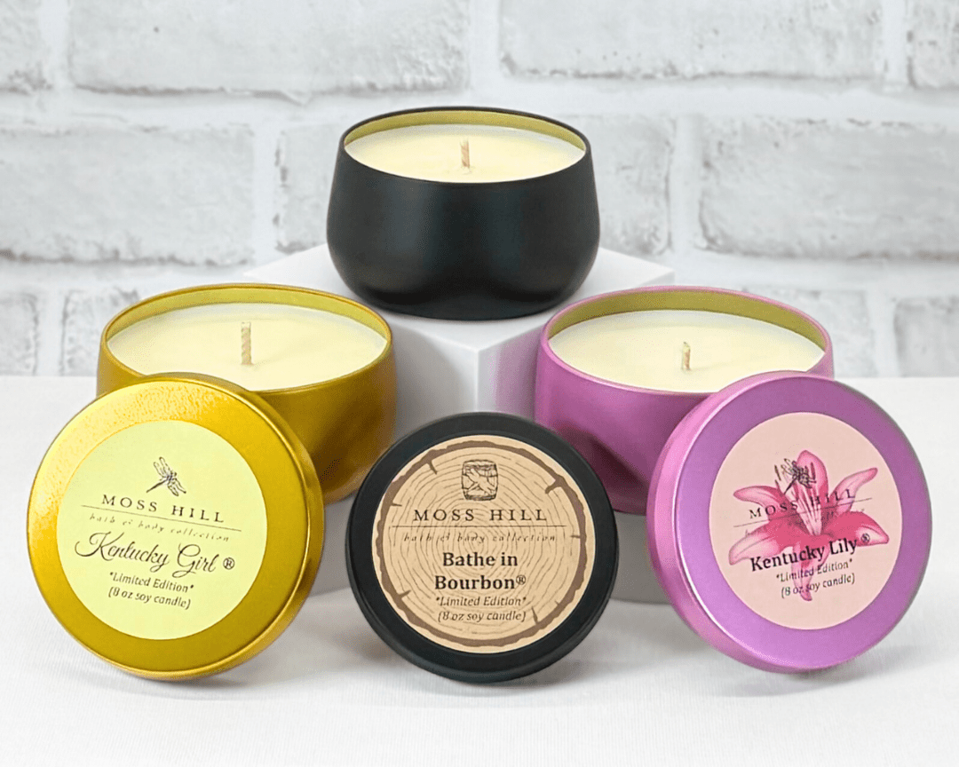 A collection of 8 oz soy candles in various colored tins, with labels indicating different fragrances.