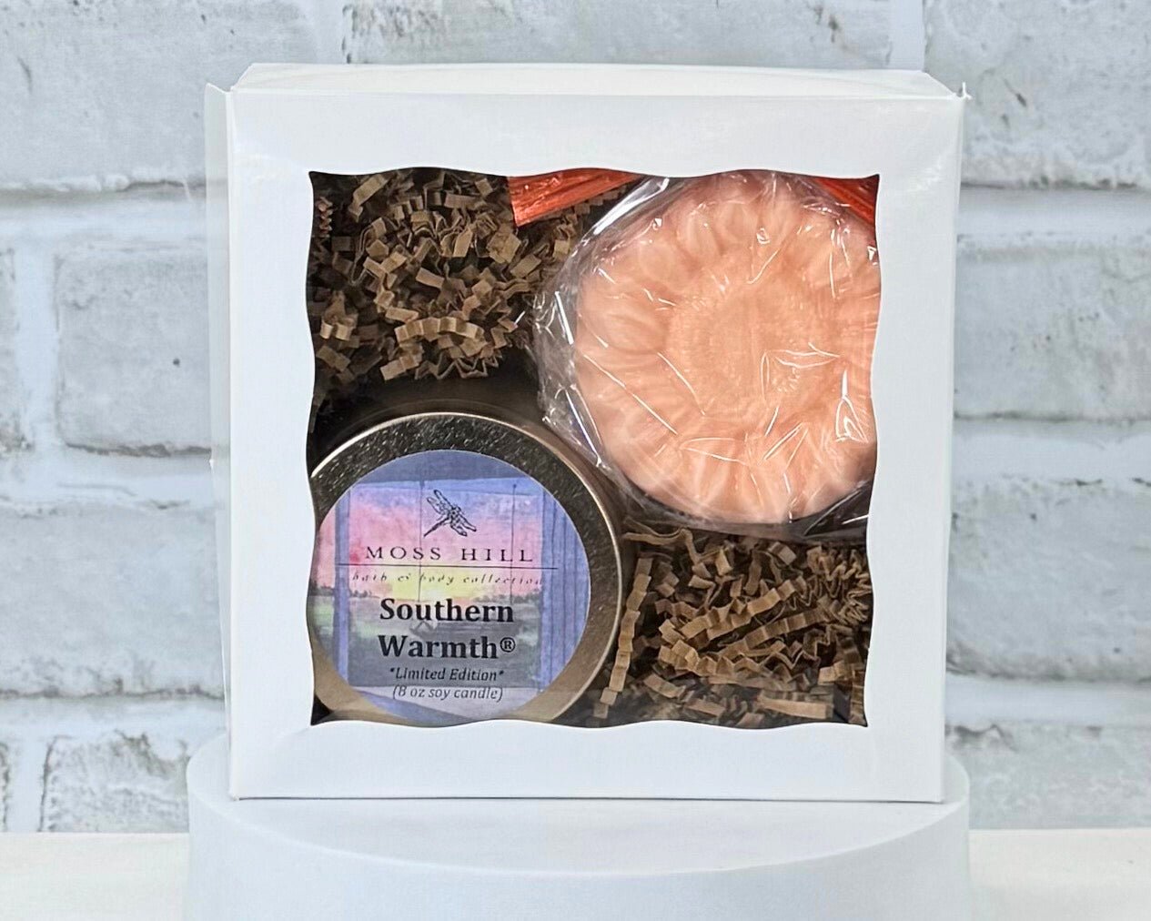 2 piece body care gift set in the scent Southern Warmth. Comes with a handmade soap and soy candle. Wrapped in a white gift box on a white background. 
