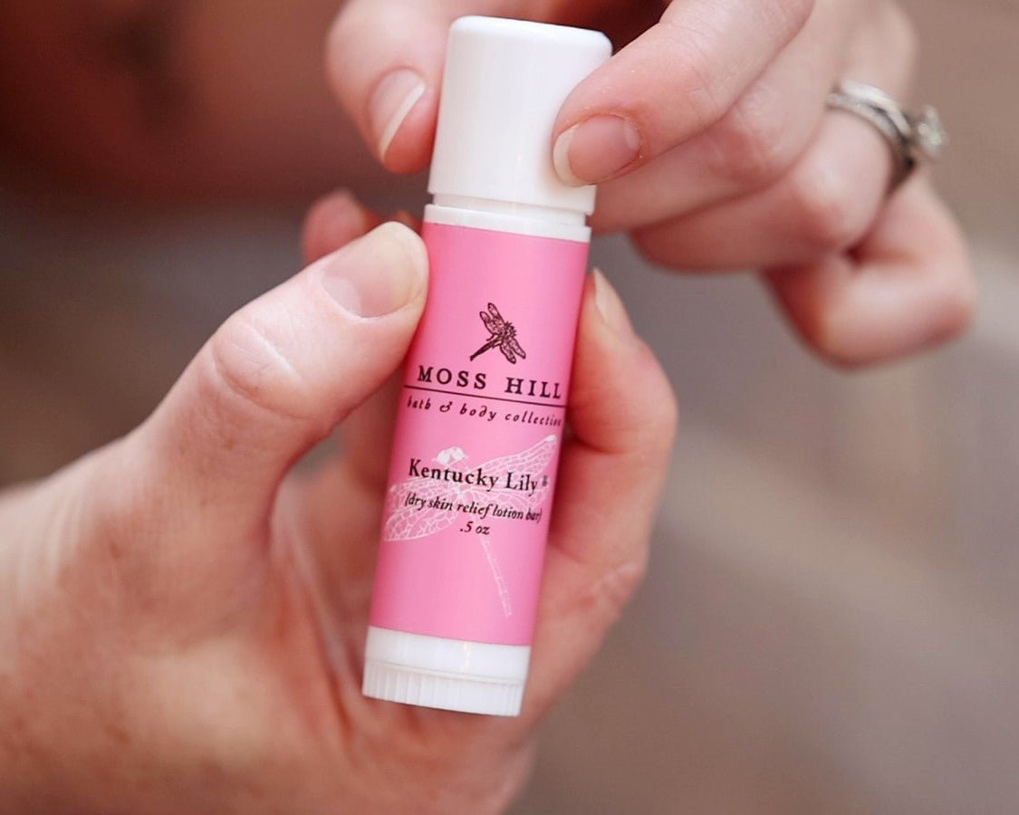 A white cap being removed from a tube of dry skin relief lotion bar.