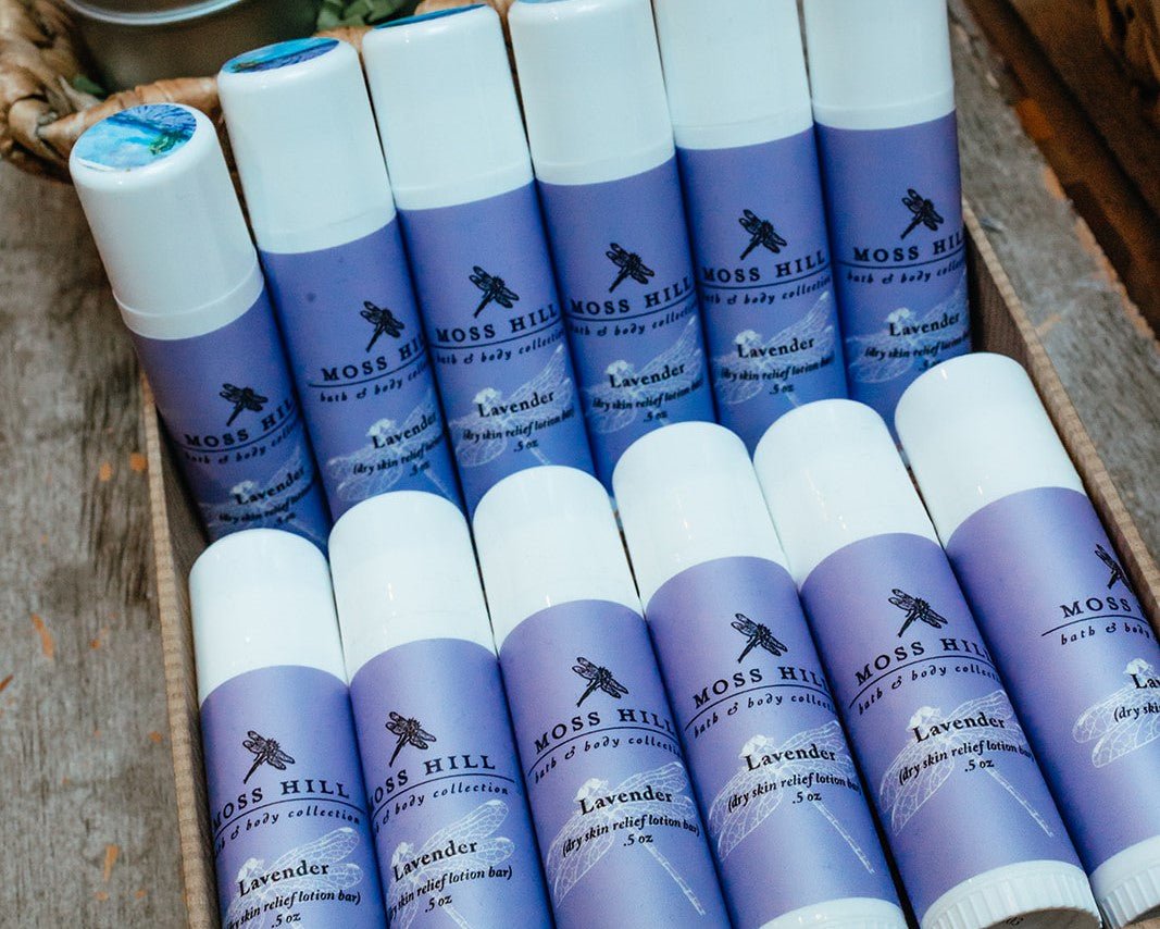 White tubes of dry skin relief lotion bar wrapped in a purple label for the lavender scent on a table display for the Moss Hill retail store in Louisville Kentucky