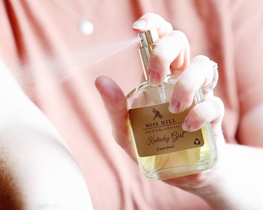 Kentucky Girl 2 oz spray perfume being misted onto a womans arm